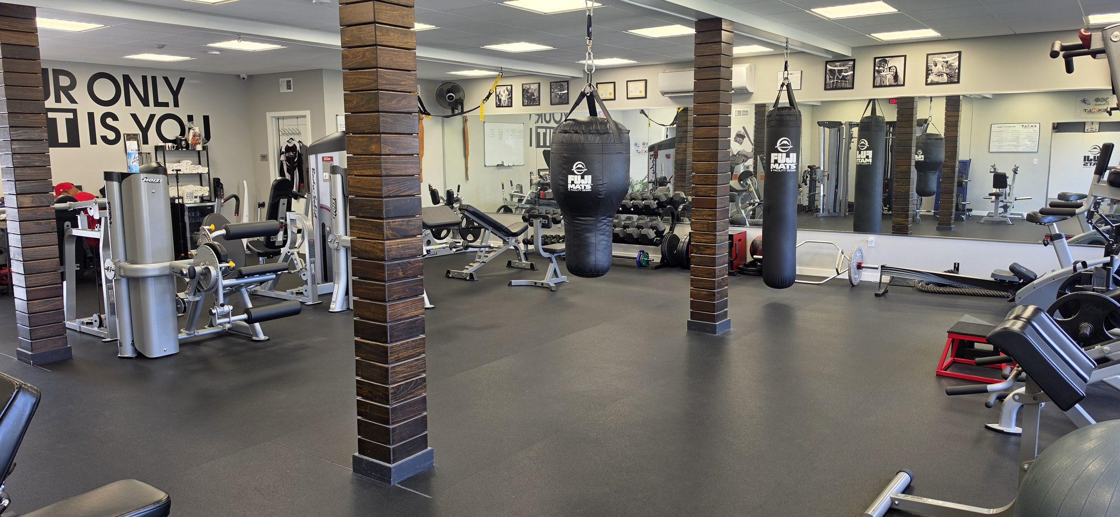Training floor with the heavy bags and the YOUR LIMIT IS YOU wall